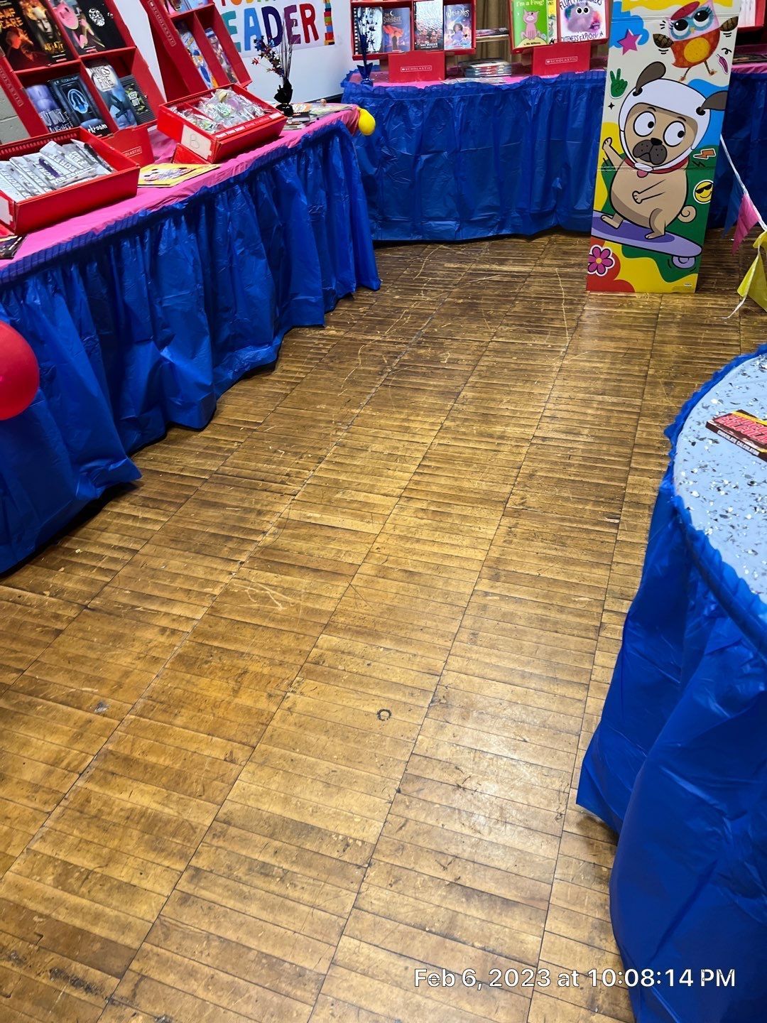 A room filled with tables and a wooden floor.