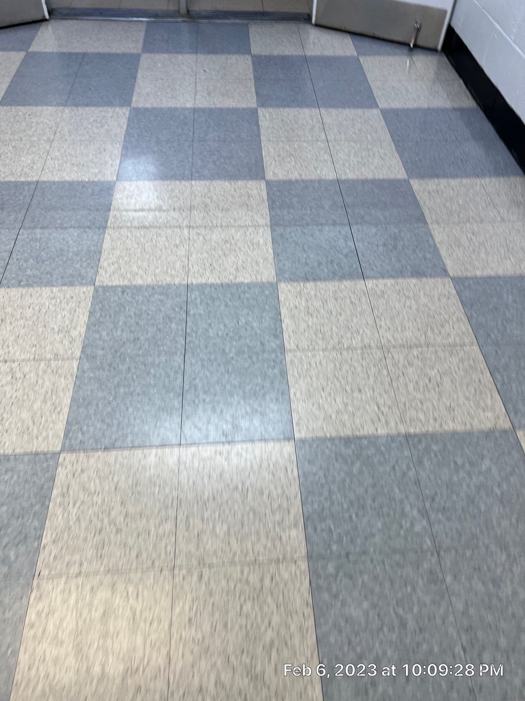 A checkered floor in a room with a date stamp
