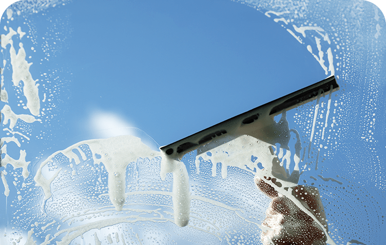 A person is cleaning a window with a squeegee.