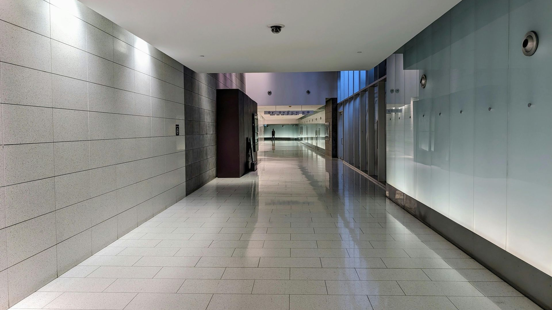 Long hallway with tile floor and light walls.
