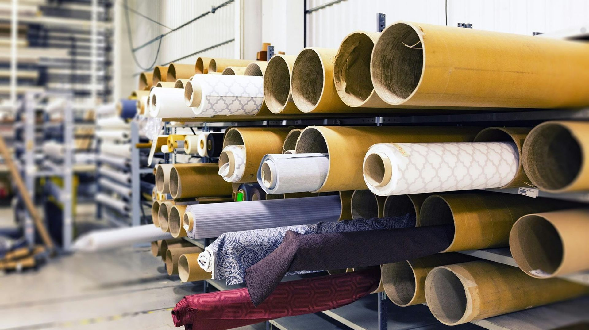 Fabric rolls on shelves in a warehouse.