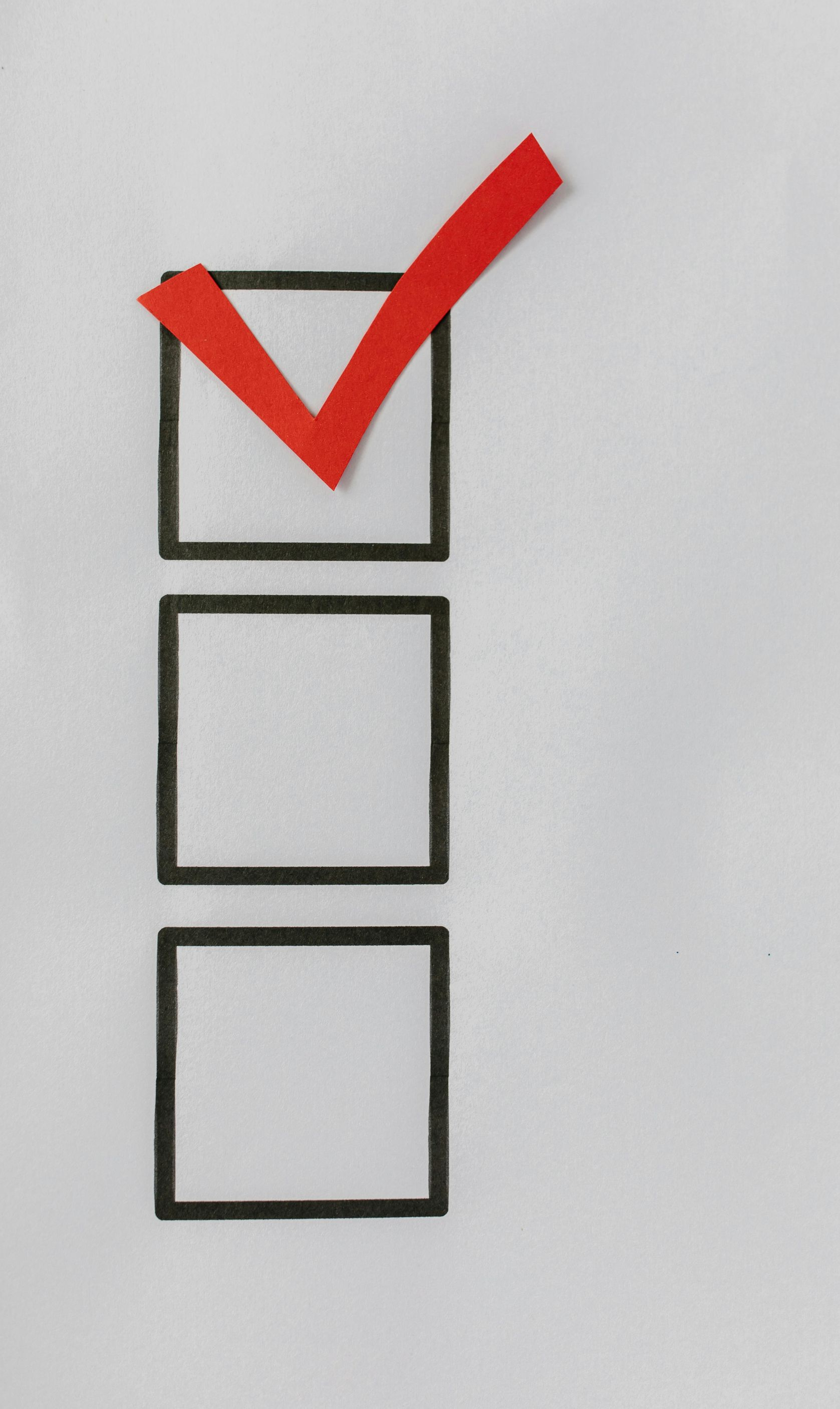 Red checkmark in the top of three empty black-bordered boxes on a white background.