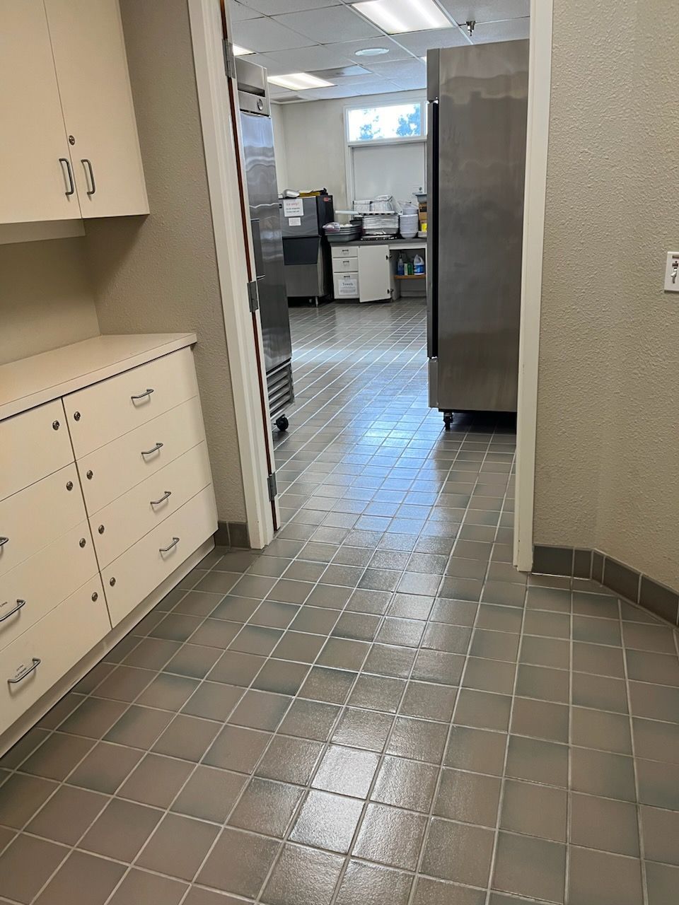 a kitchen with a tiled floor and stainless steel appliances .