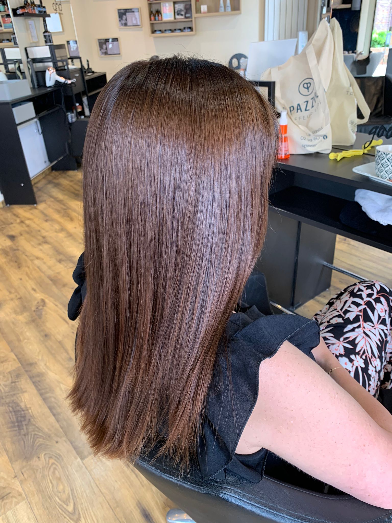 Une femme est assise sur une chaise avec ses cheveux dans un salon.