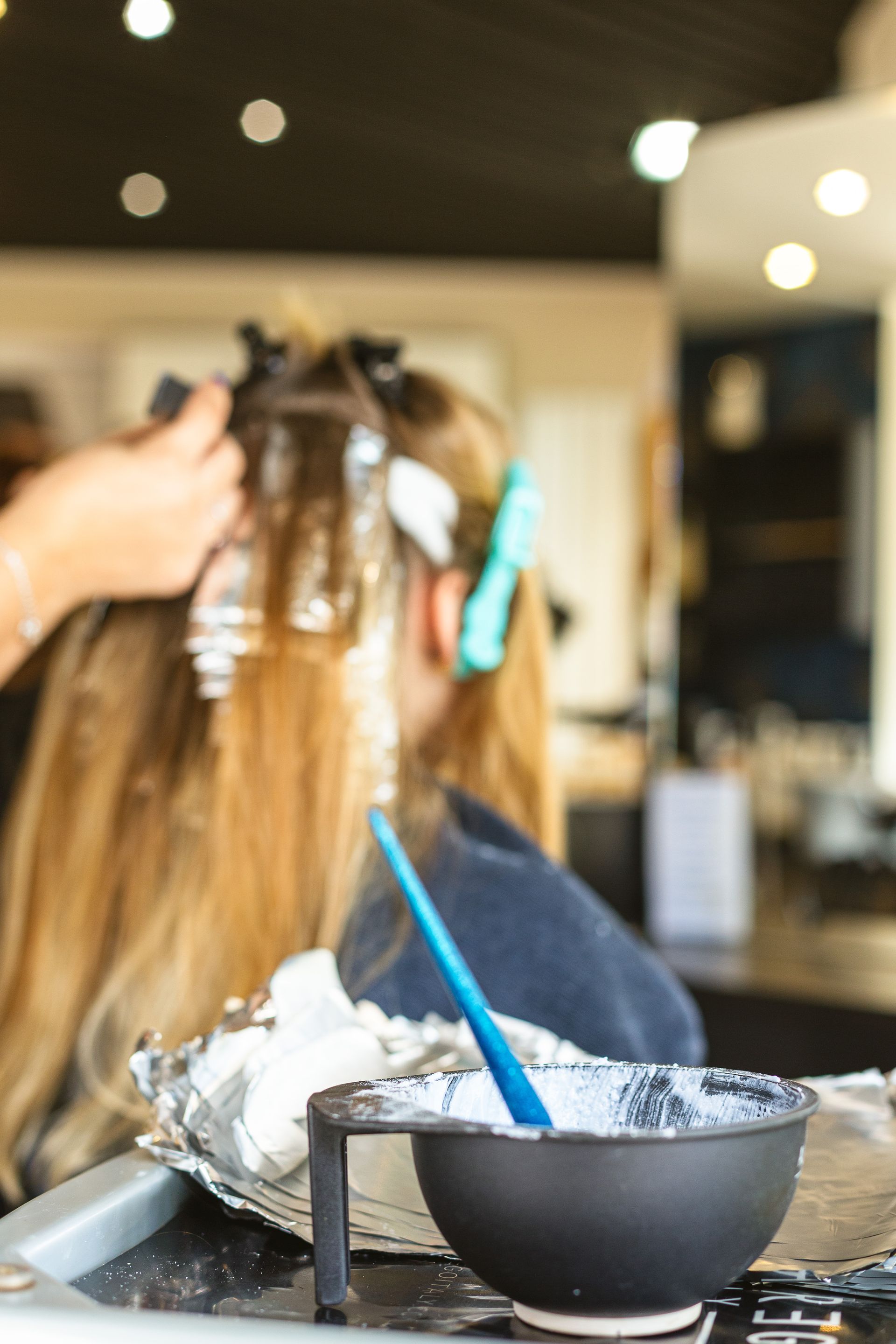 Une femme se fait teindre les cheveux dans un salon.