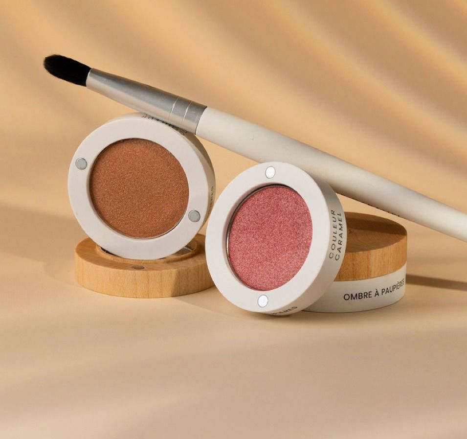 Deux ombres à paupières et un pinceau sur une table