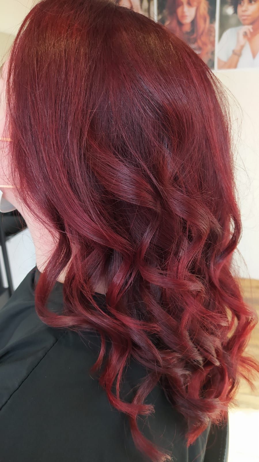 Une femme aux cheveux roux est assise sur une chaise dans un salon.