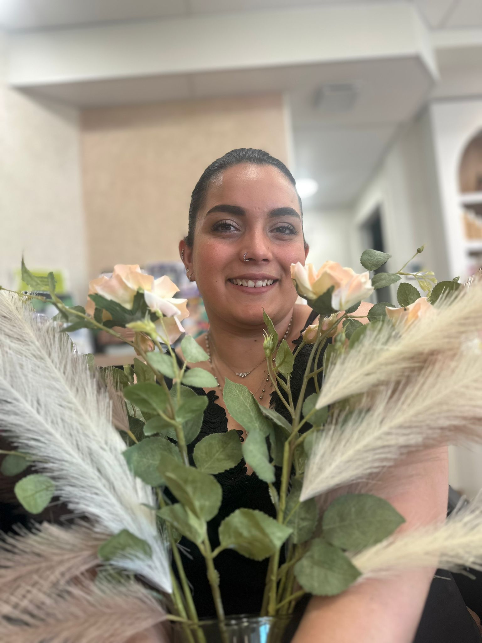 Une femme aux cheveux violets et aux lèvres rouges porte une chemise noire.