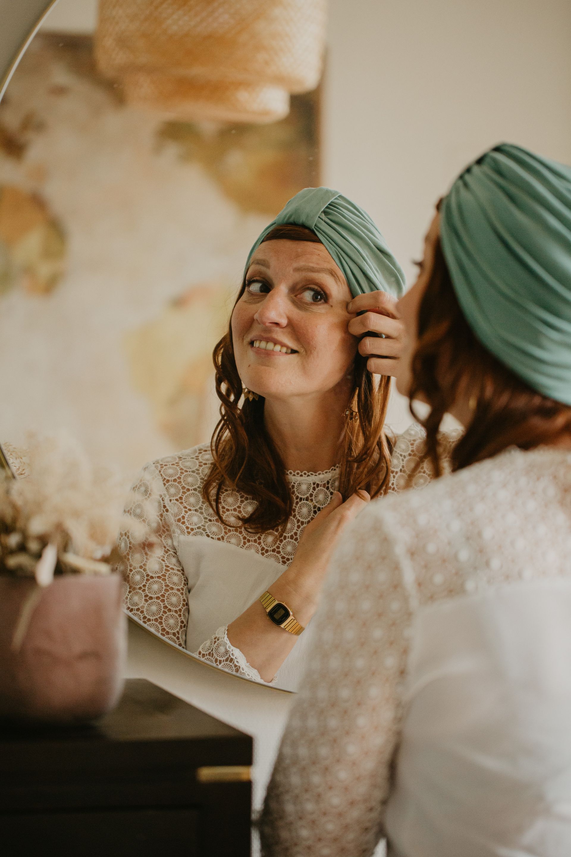 Une femme portant un turban se regarde dans le miroir.