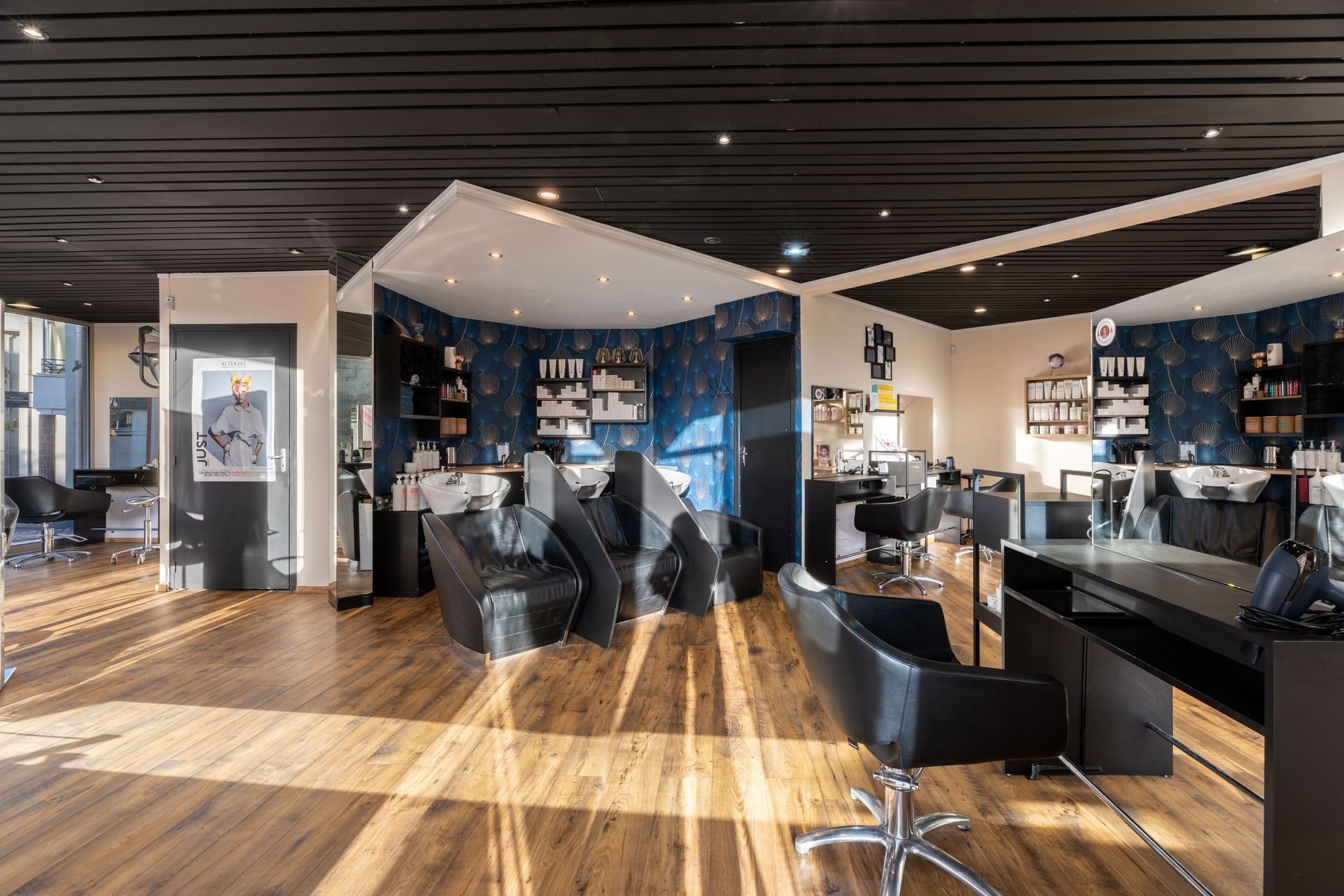 Une grande pièce avec beaucoup de chaises et de tables dans un salon de coiffure.