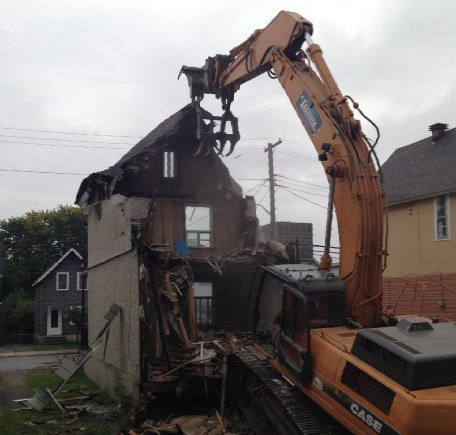 a large case excavator is demolishing a house