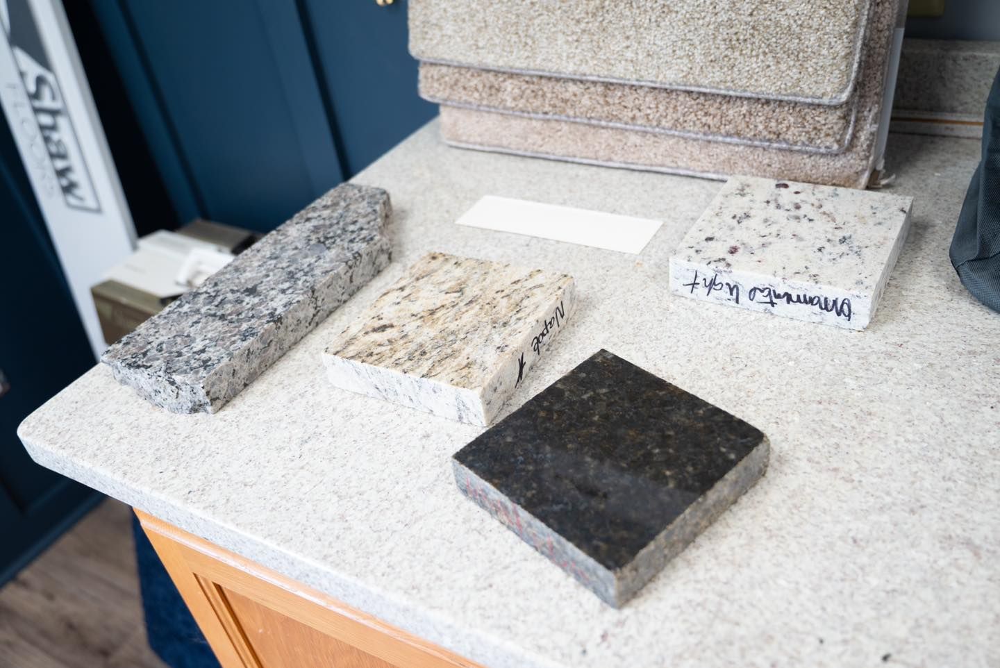 Countertop with granite and carpet samples; neutral colors, lit interior.