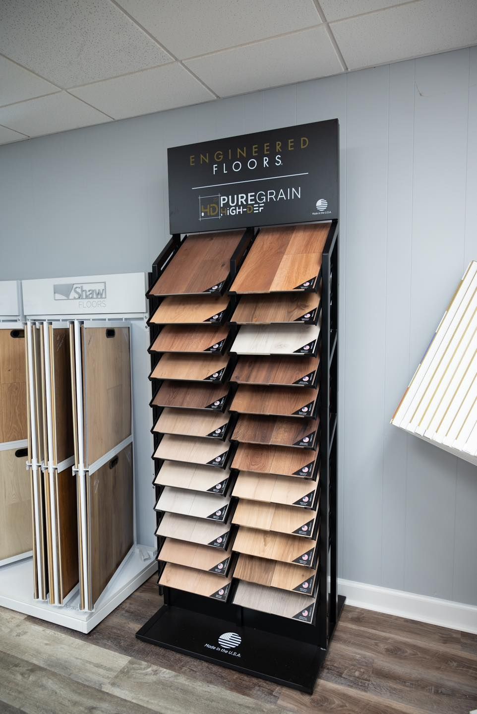 Display rack of wood flooring samples in a showroom with neutral-colored walls.