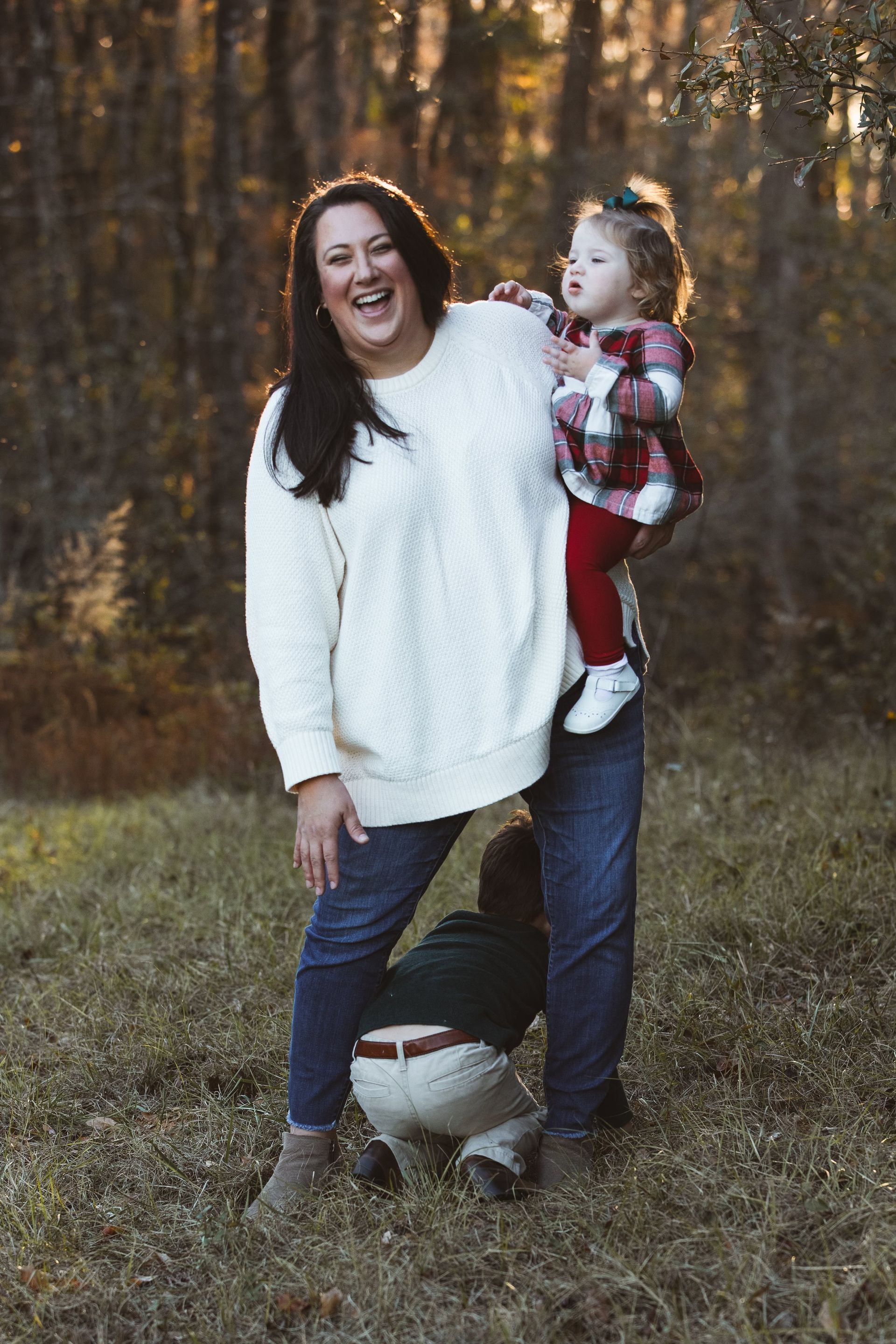 A woman is holding a little girl in her arms in a field.