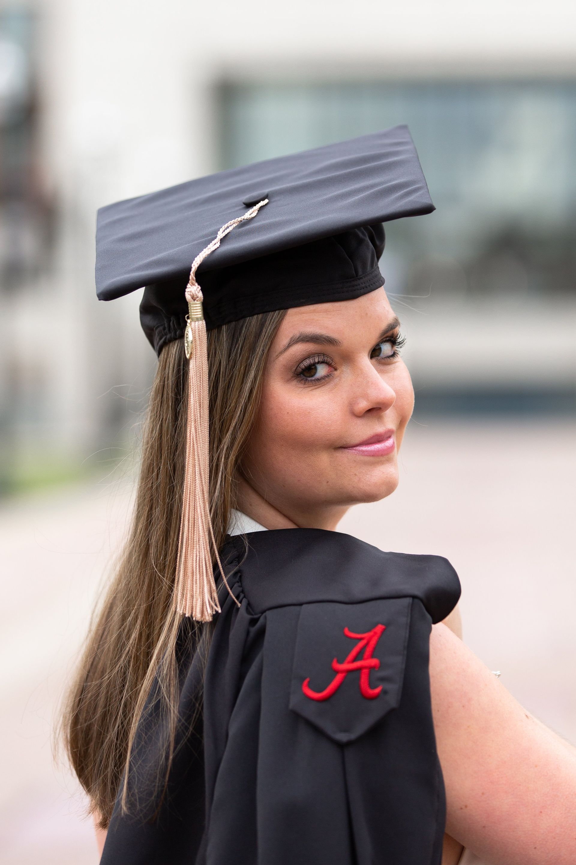 A woman is wearing a graduation cap and gown.