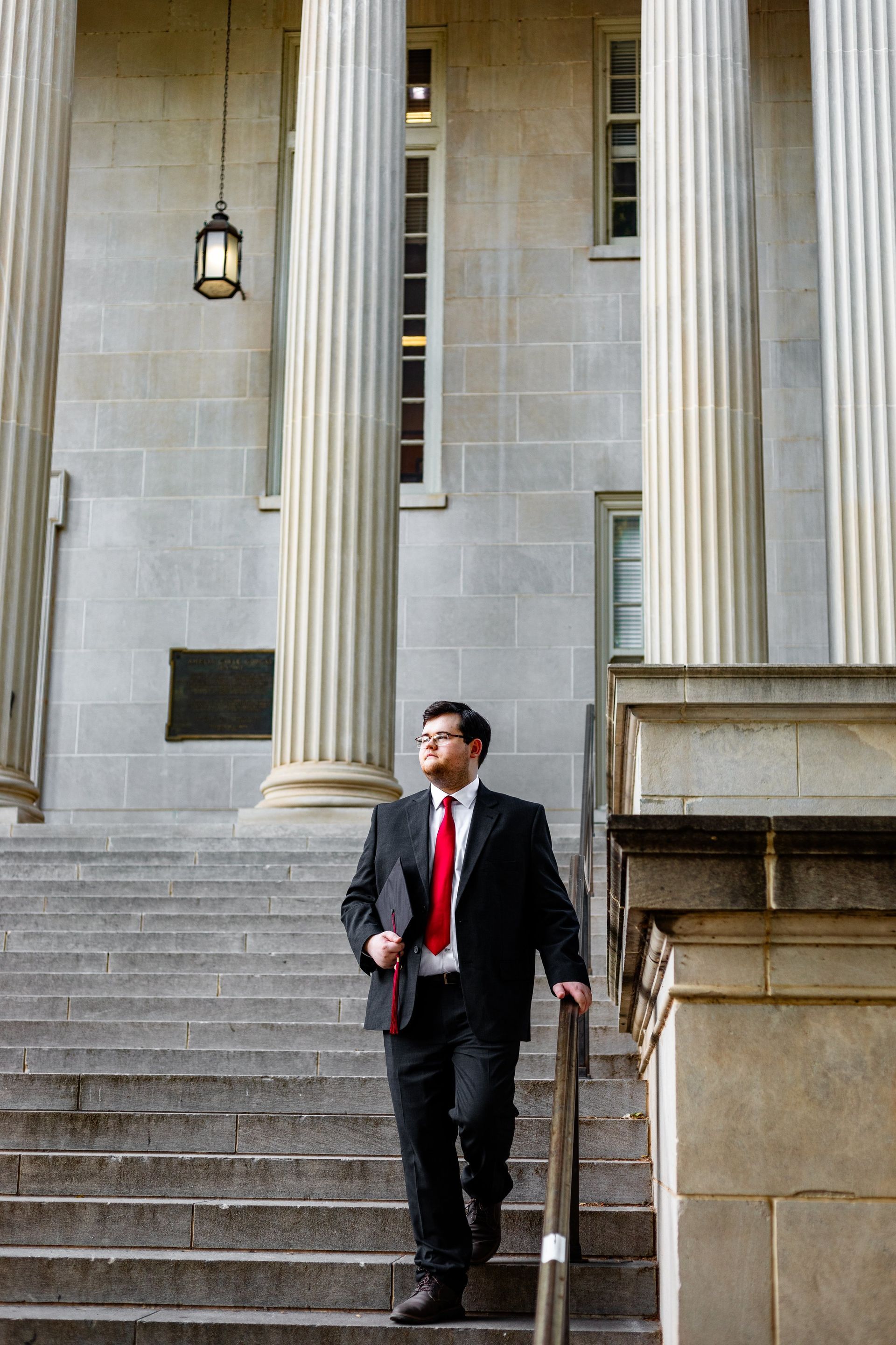A man in a suit and tie is walking up the stairs of a building.