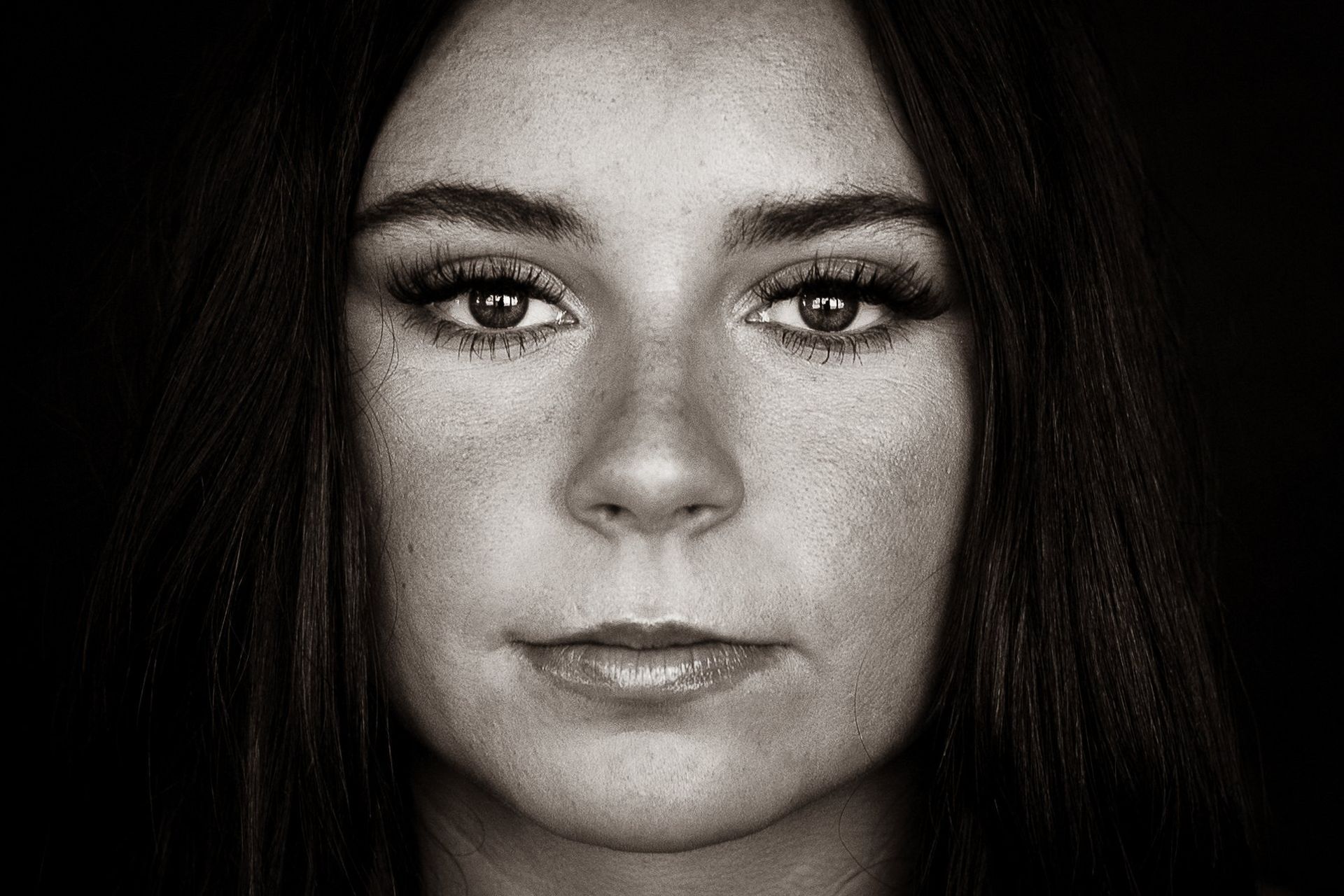 A black and white photo of a woman 's face with freckles.