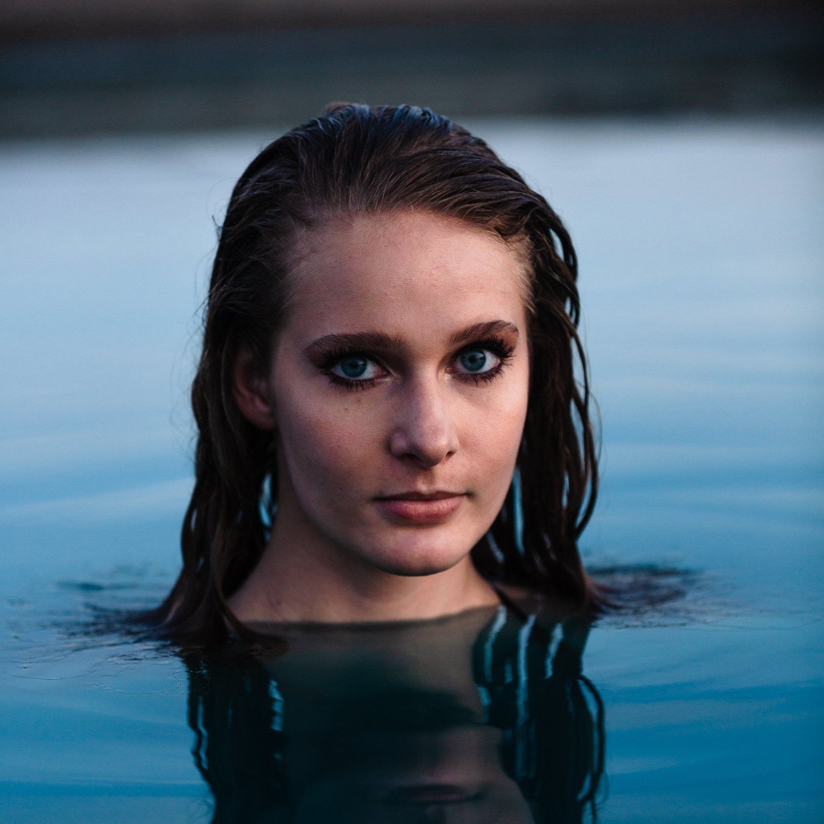 A woman is swimming in a pool with her head in the water.