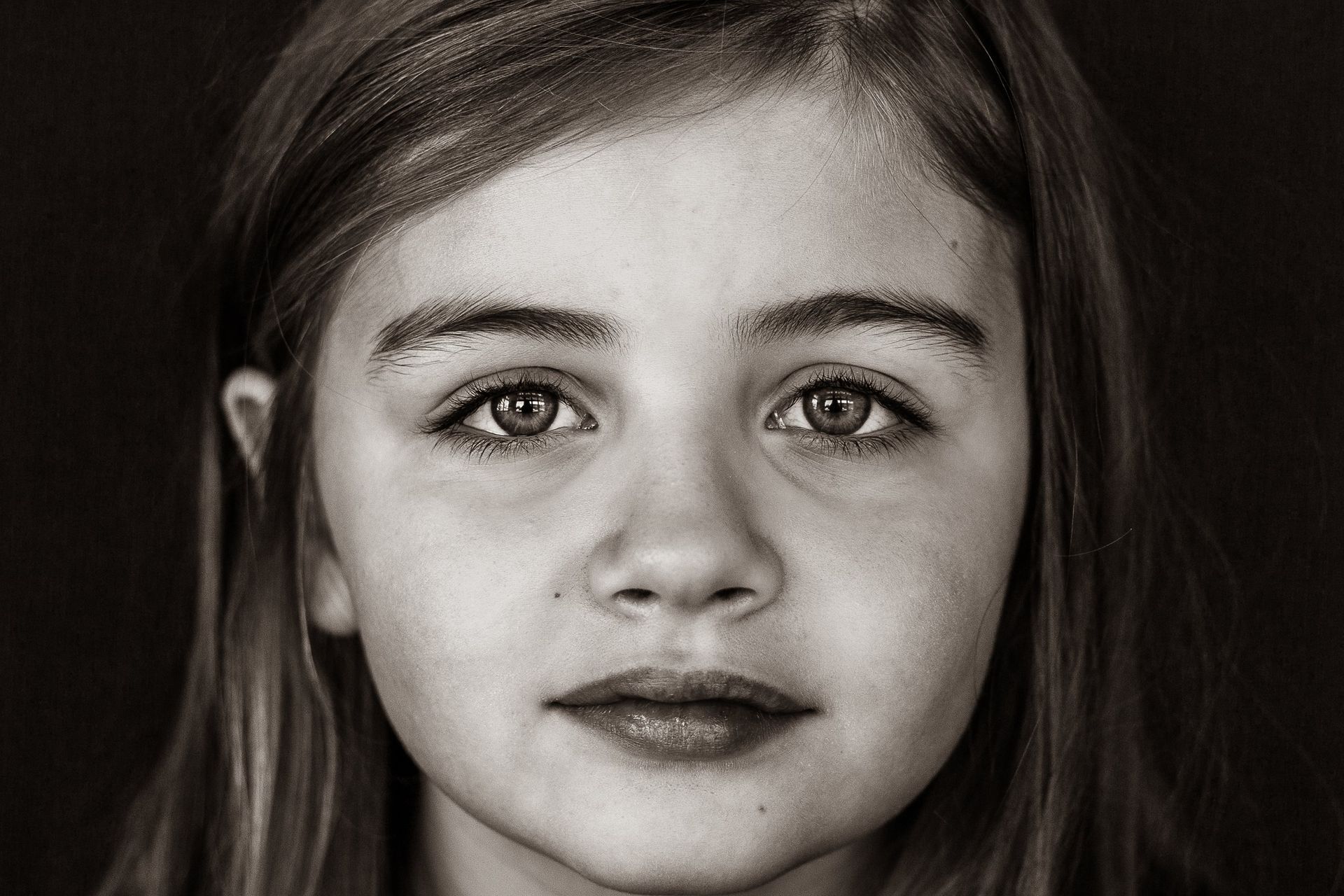 A black and white photo of a young girl 's face.