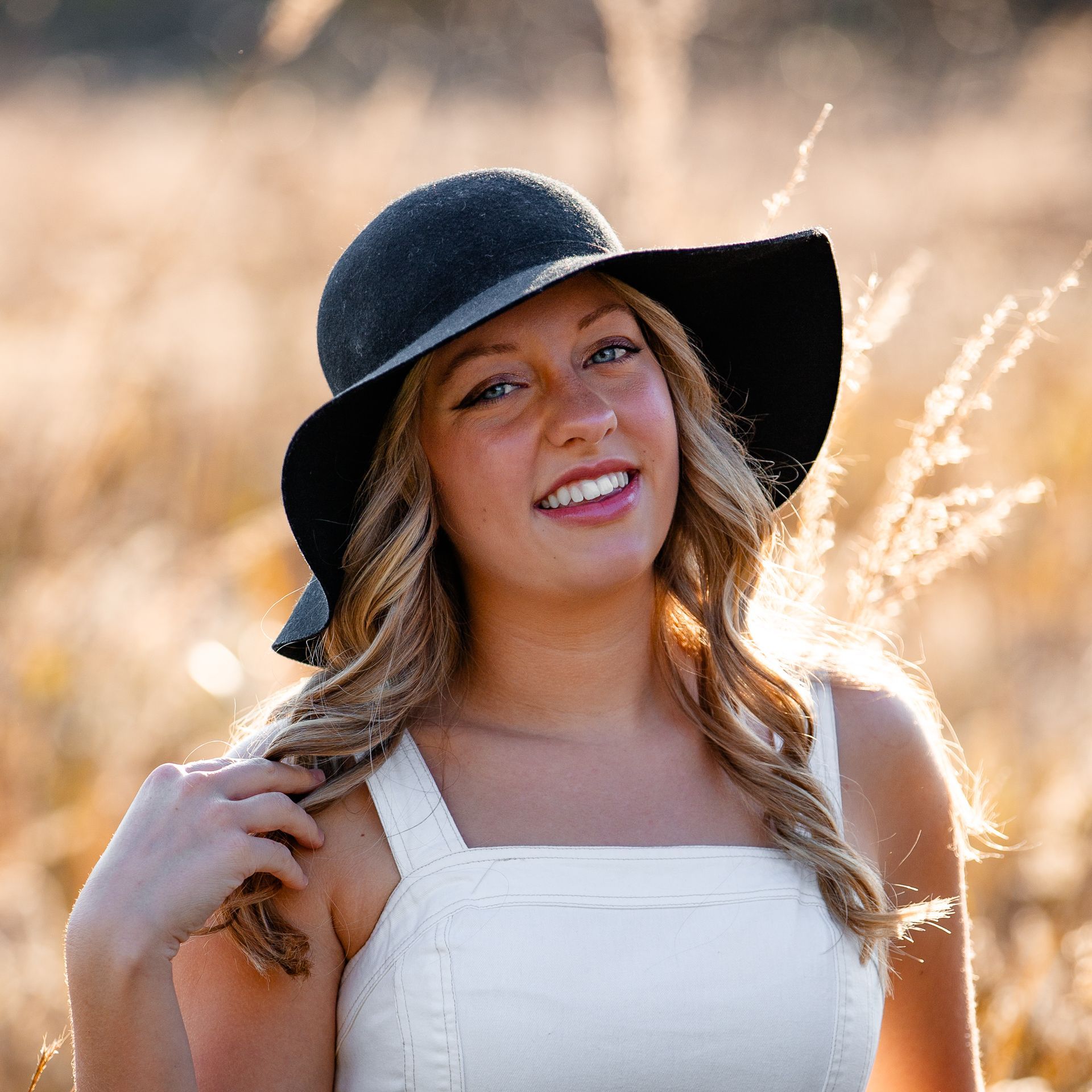 A young man with curly hair and blue eyes is leaning against a railing.