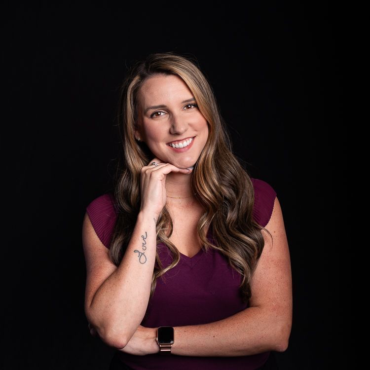 A woman with a tattoo on her arm is smiling for the camera.