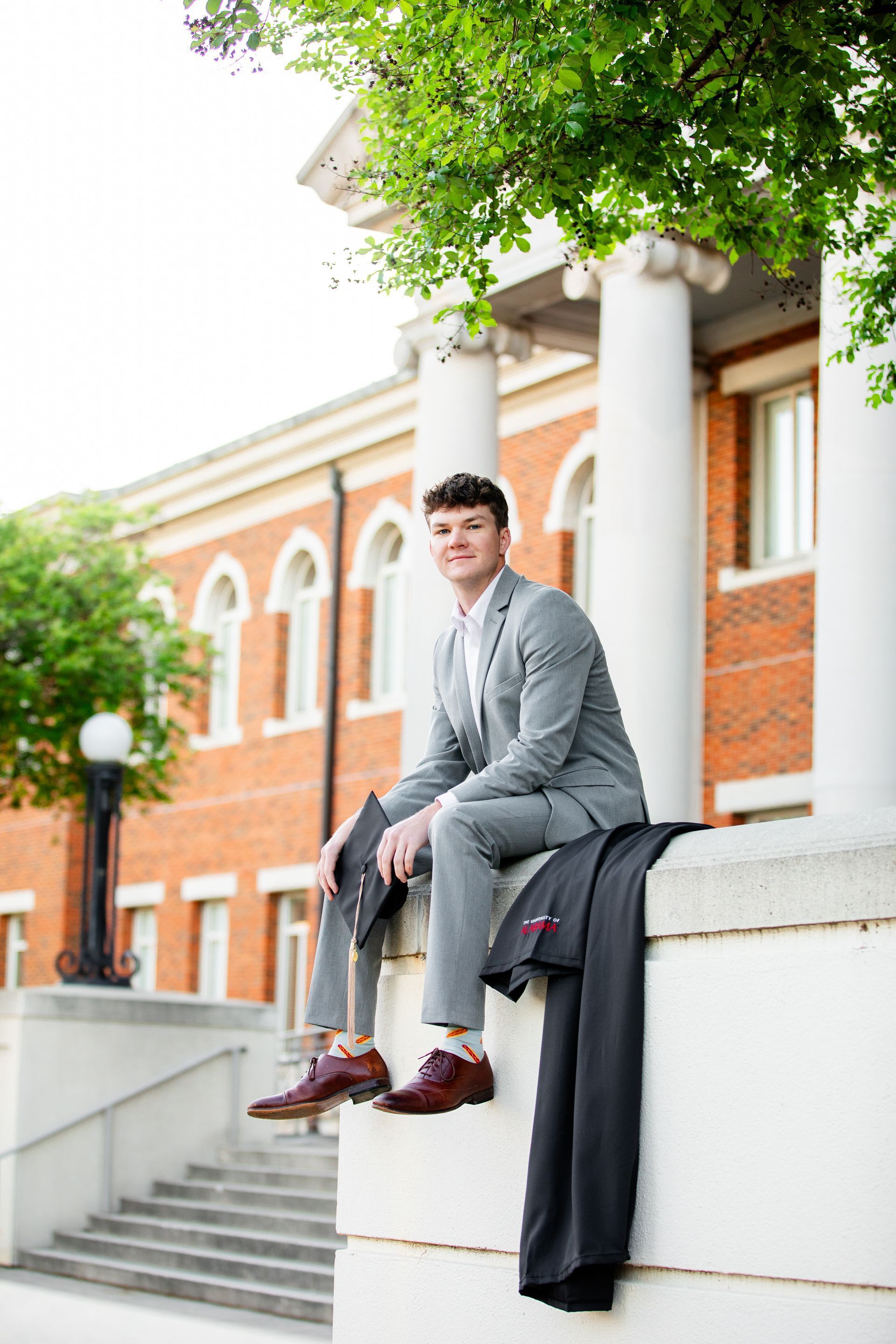 A man in a suit is sitting on the steps of a building.