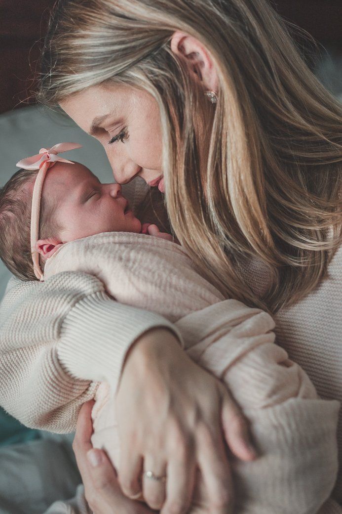 A woman is holding a newborn baby in her arms.