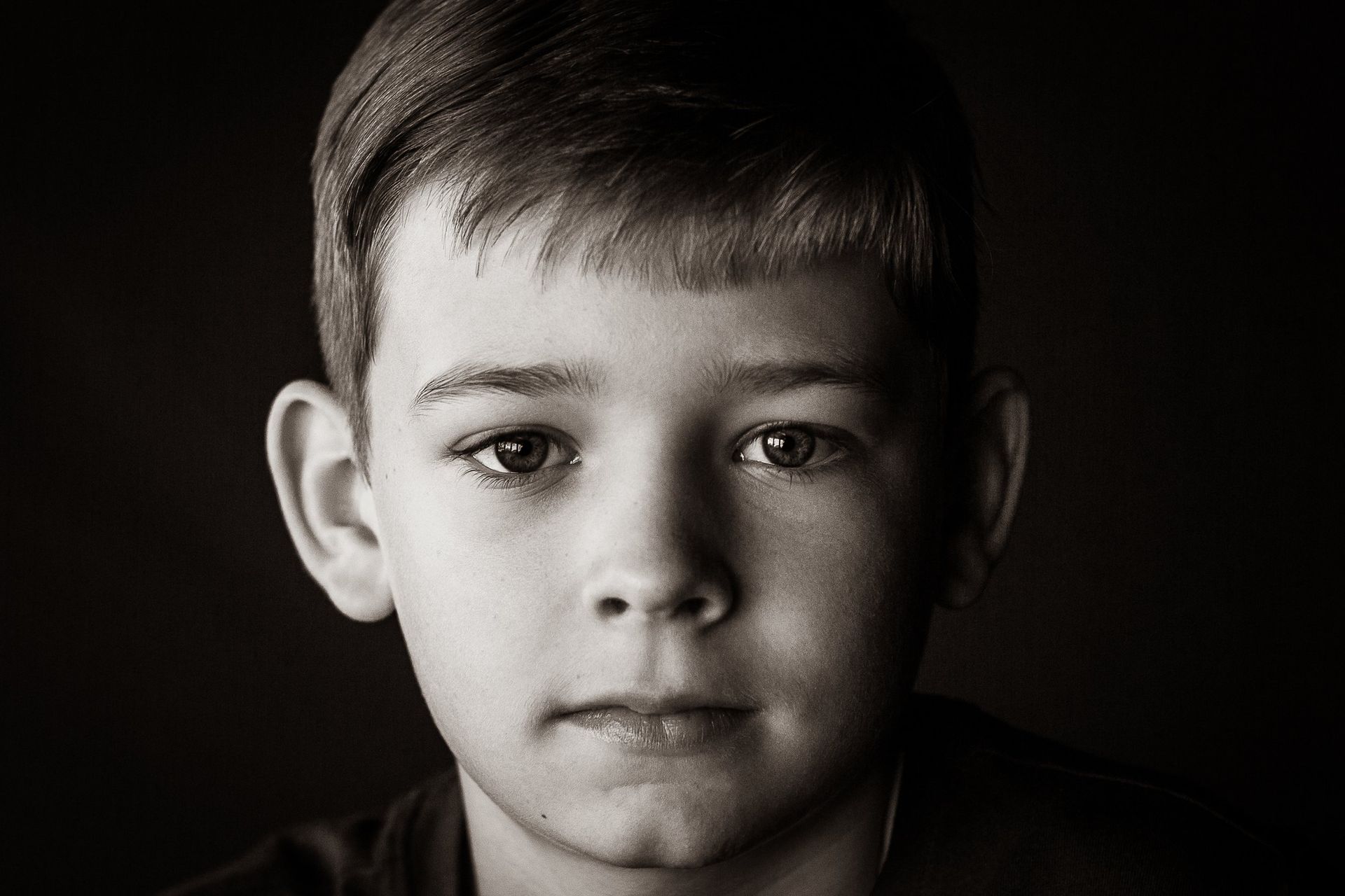 A black and white photo of a young boy 's face.