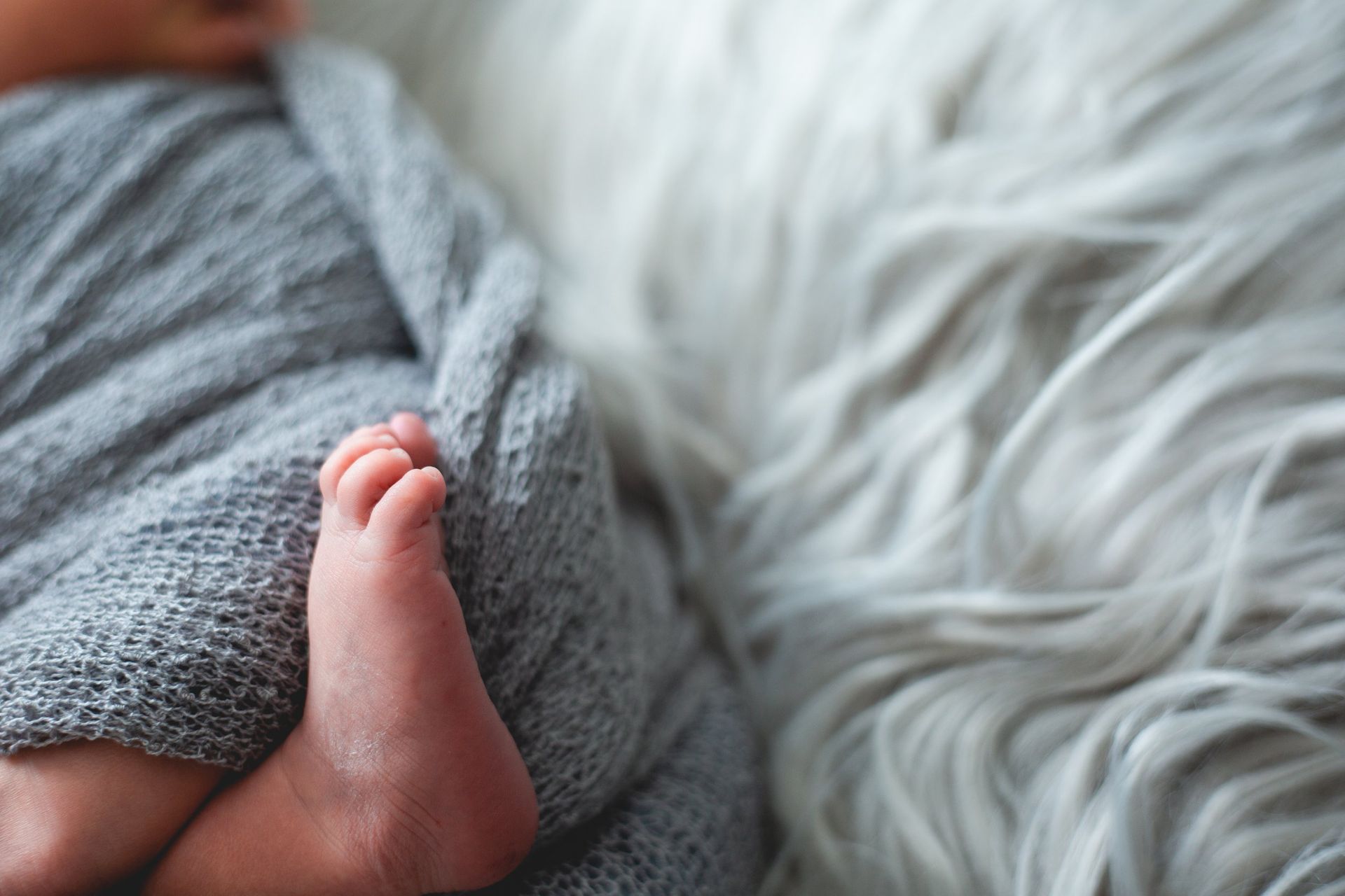 A close up of a baby 's foot wrapped in a blanket.