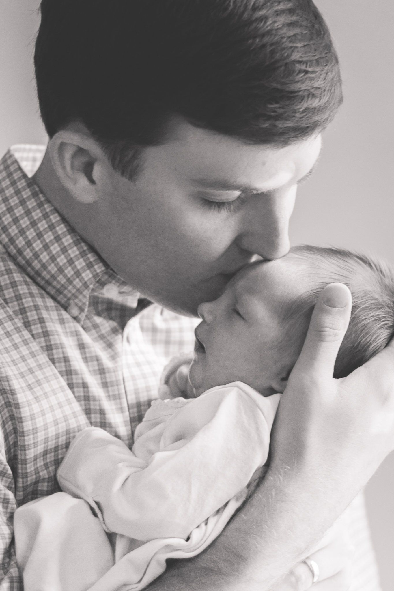 Man dressed up holding newborn baby.