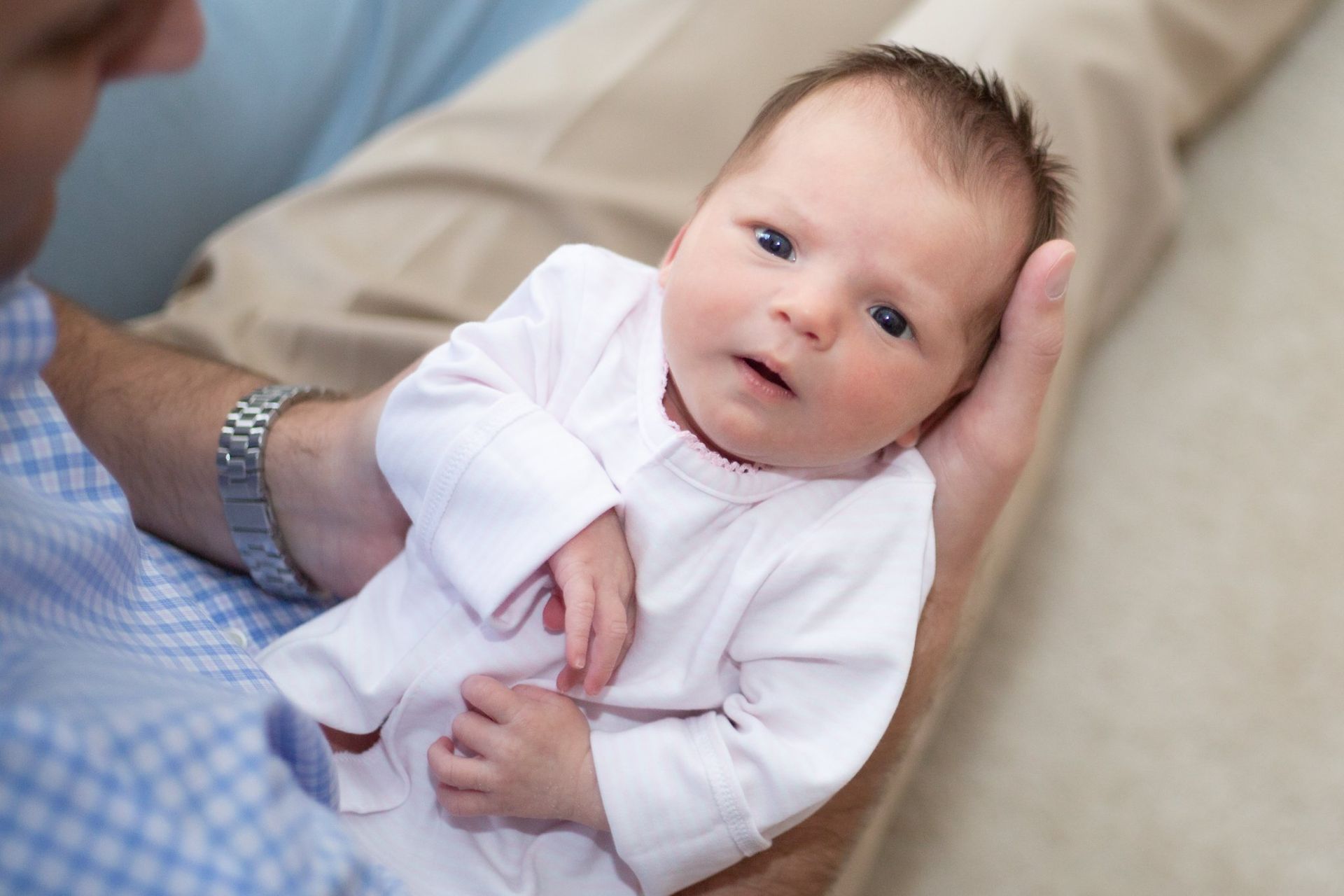 A man is holding a newborn baby in his arms.