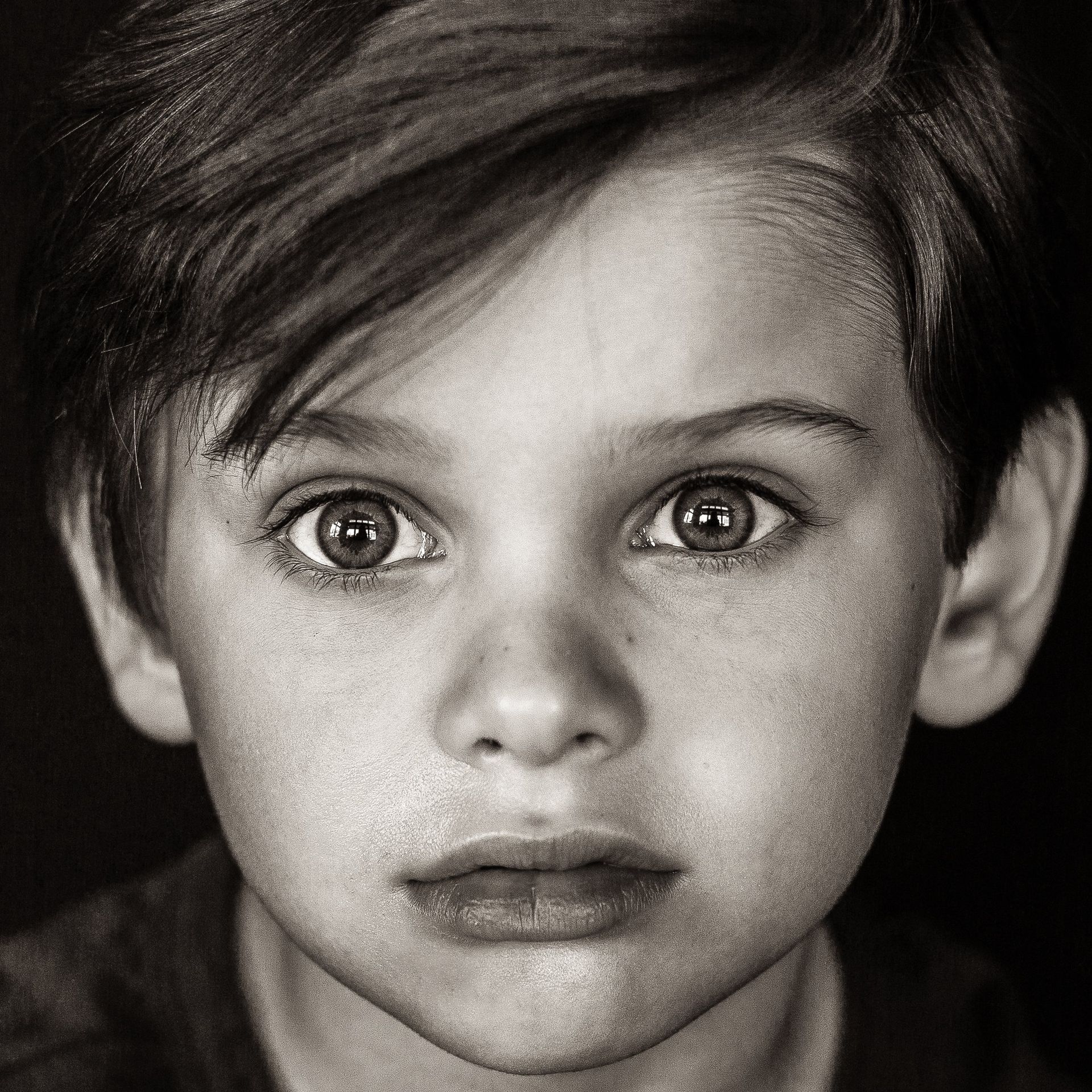 A black and white photo of a young boy 's face