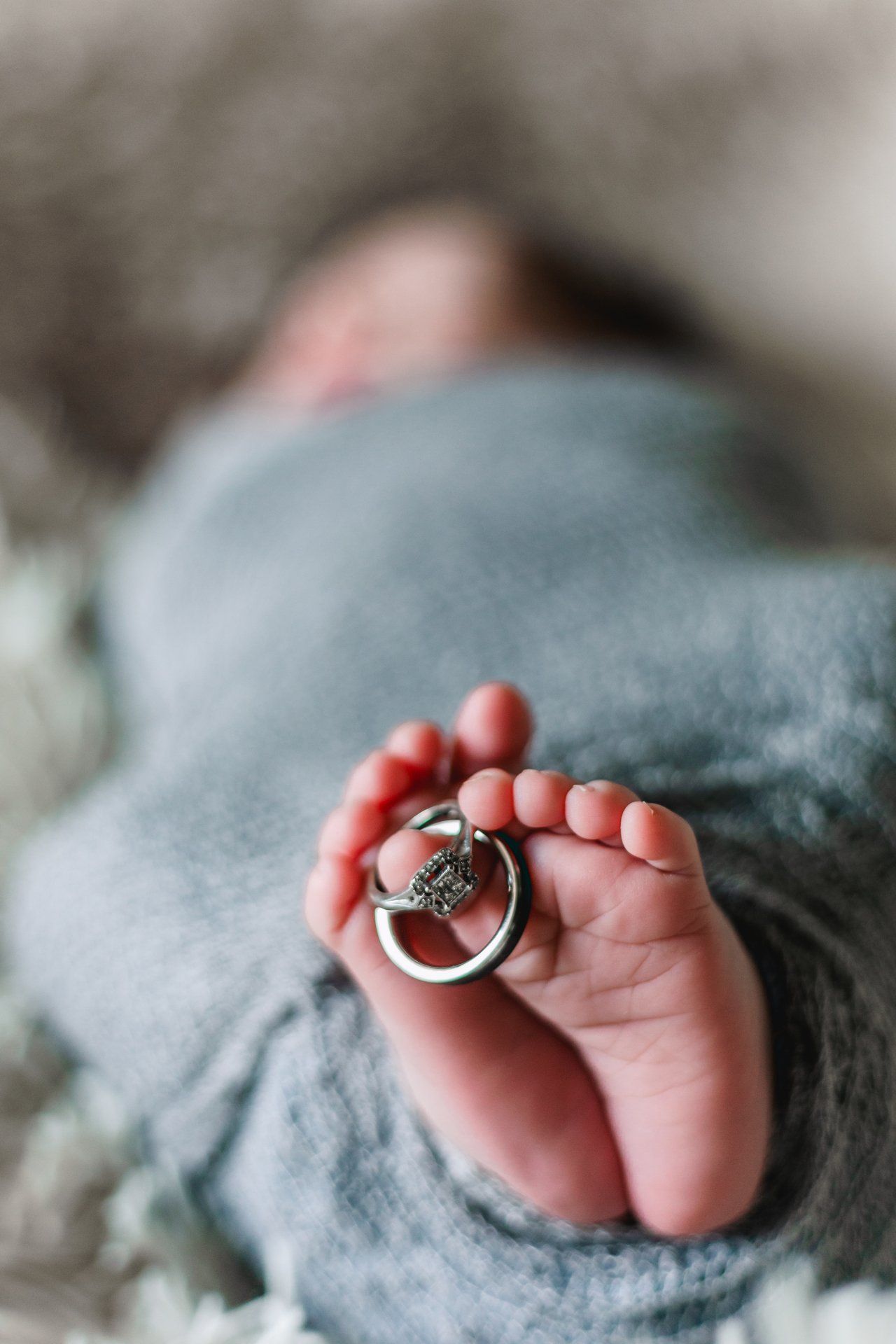 A close up of a baby 's feet with wedding rings on them.