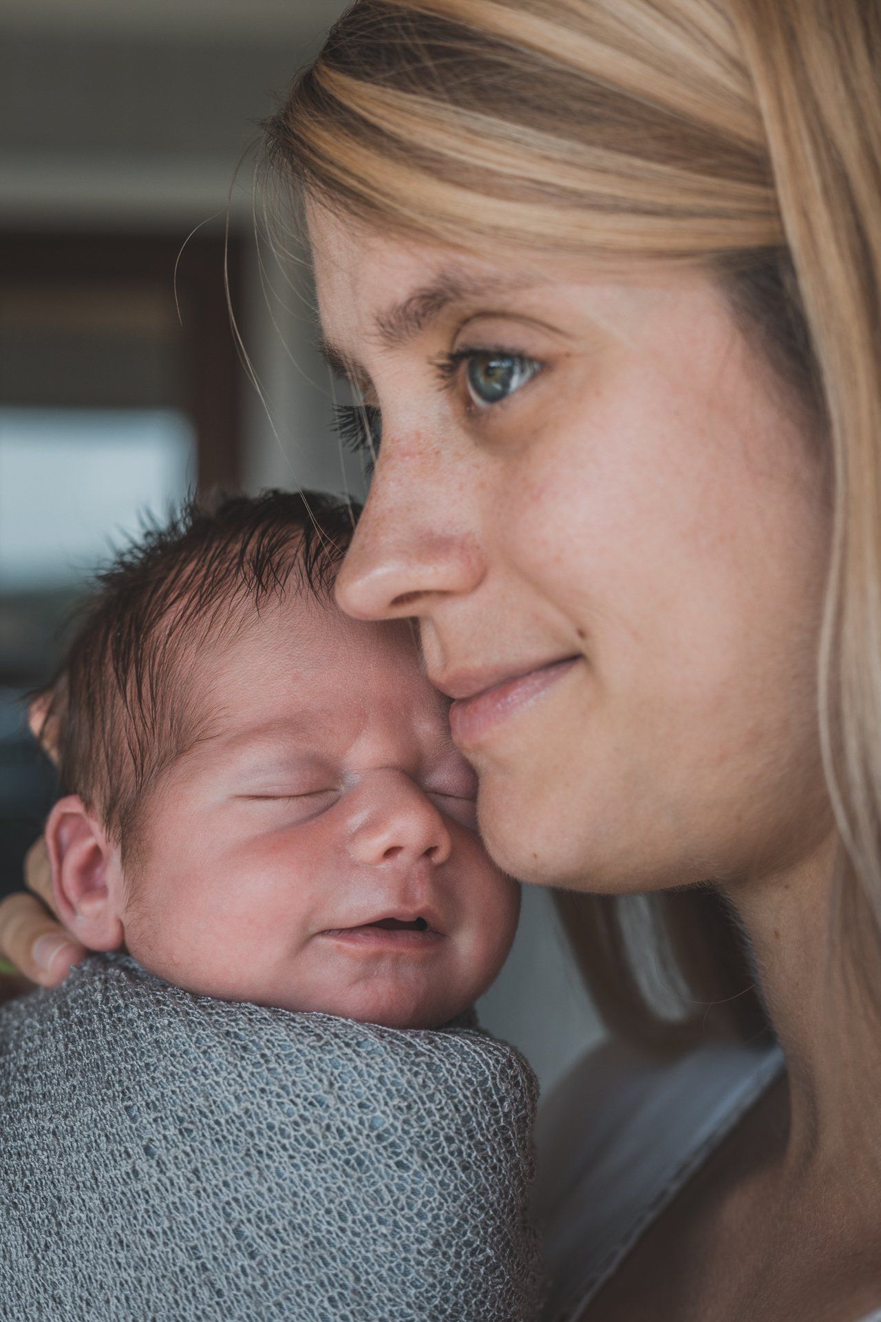 A woman is holding a newborn baby in her arms.