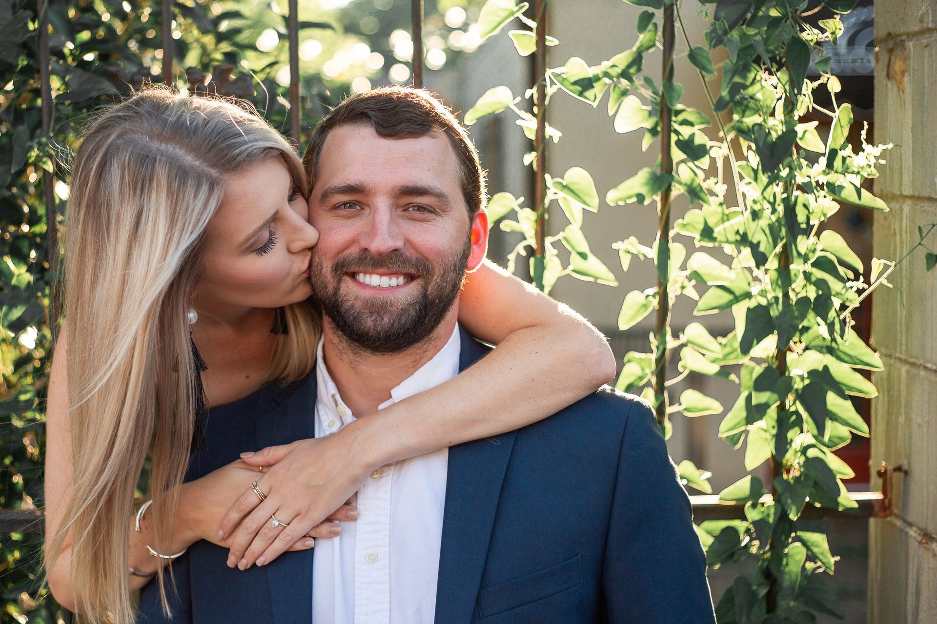 A woman is kissing a man on the cheek.
