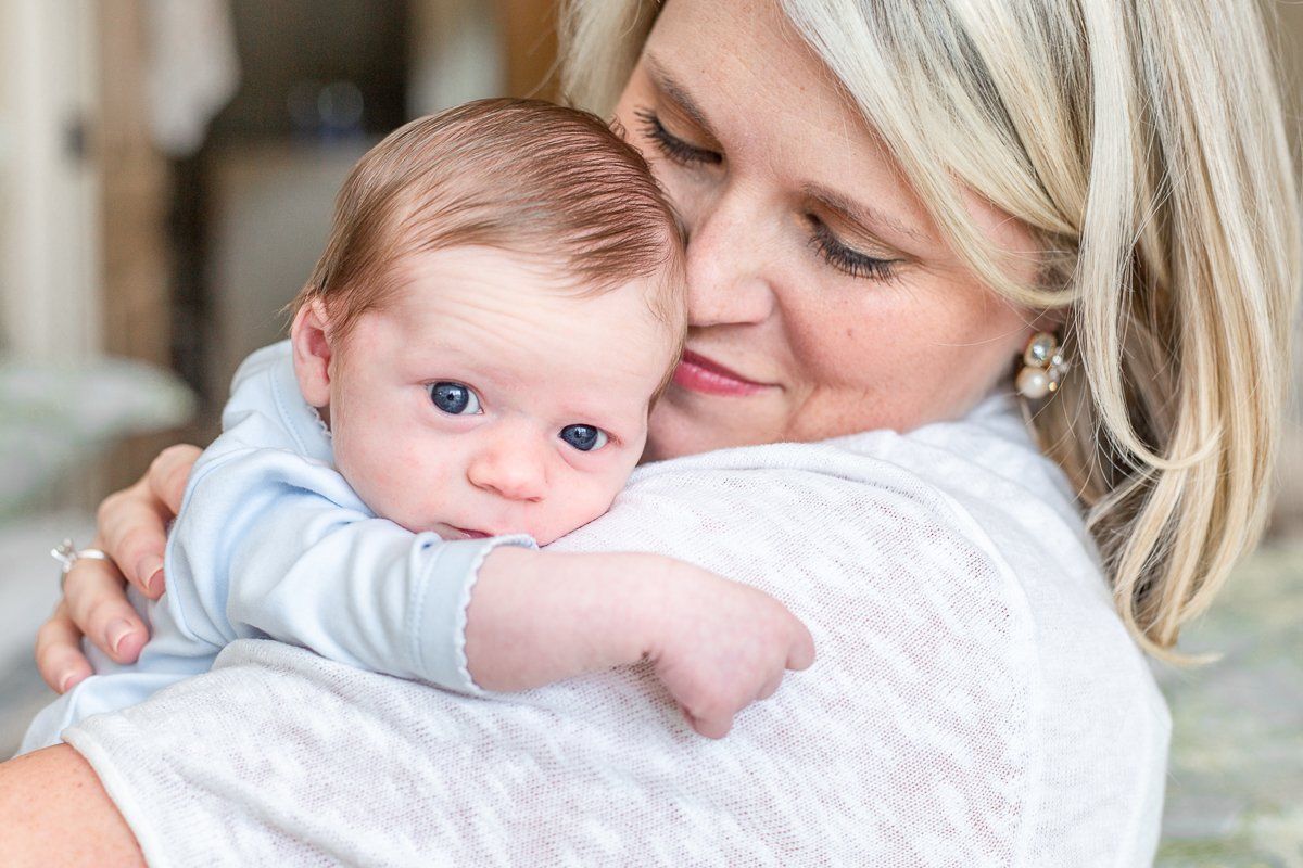 A woman is holding a baby in her arms.