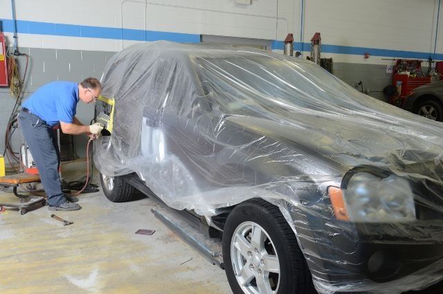 Man Repairing a Covered Car — Auto Repair in Braintree,, MA
