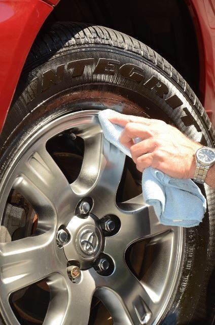 Man Cleaning a Tire with a Cloth — Auto Repair in Braintree,, MA