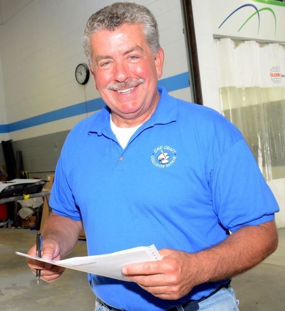Man Wearing Blue Shirt Holding a Paper — Auto Repair in Braintree,, MA