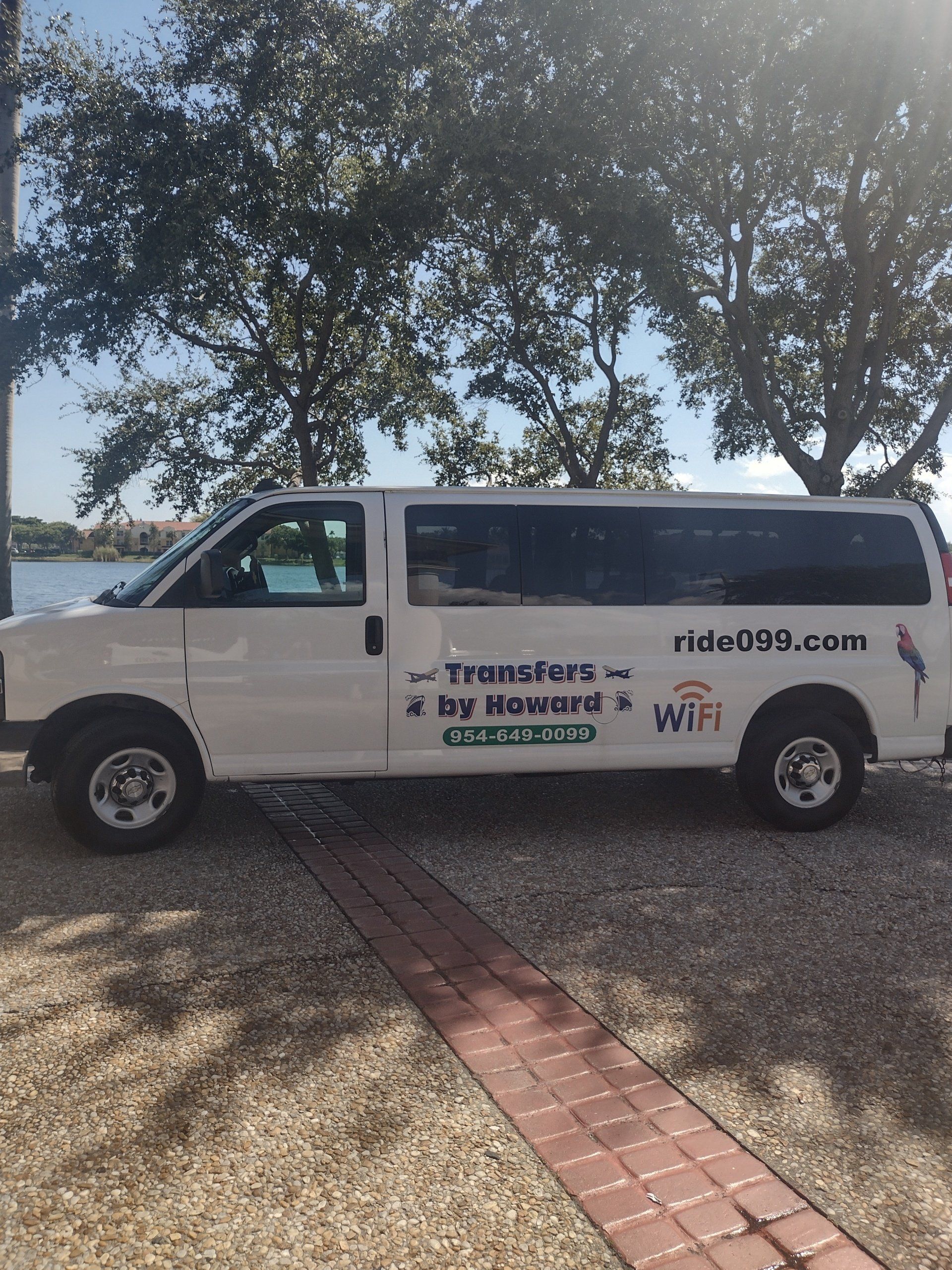 A white van is parked next to a brick walkway