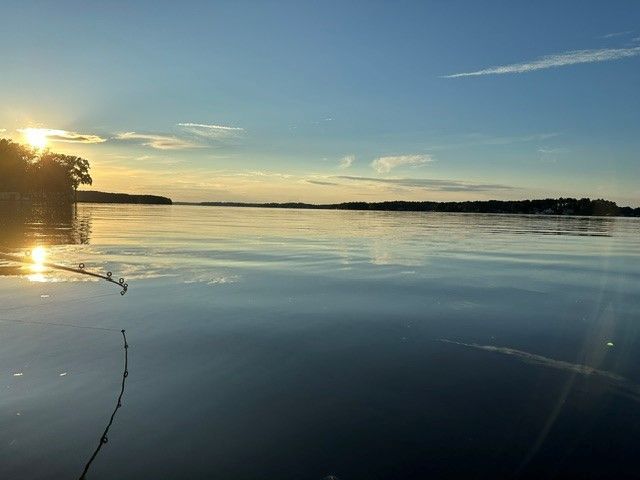 Sunset over Lake Gaston with golden reflections and a tree-lined shore