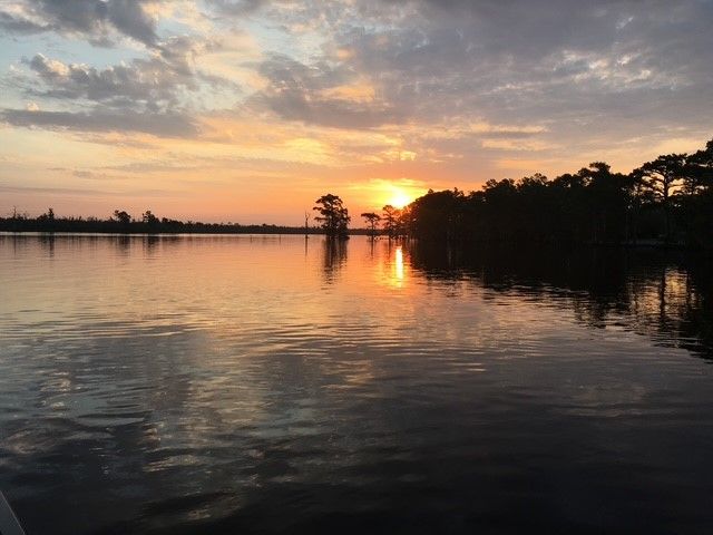 Sunset over Lake Gaston with silhouetted trees and orange reflections on the water