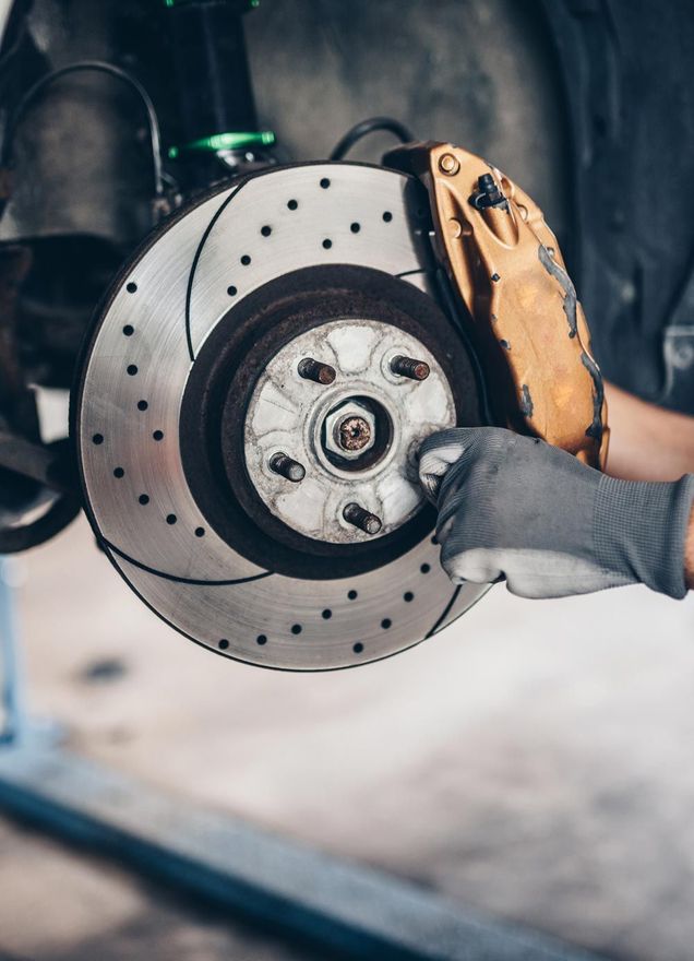 A person is fixing a brake disc on a car.