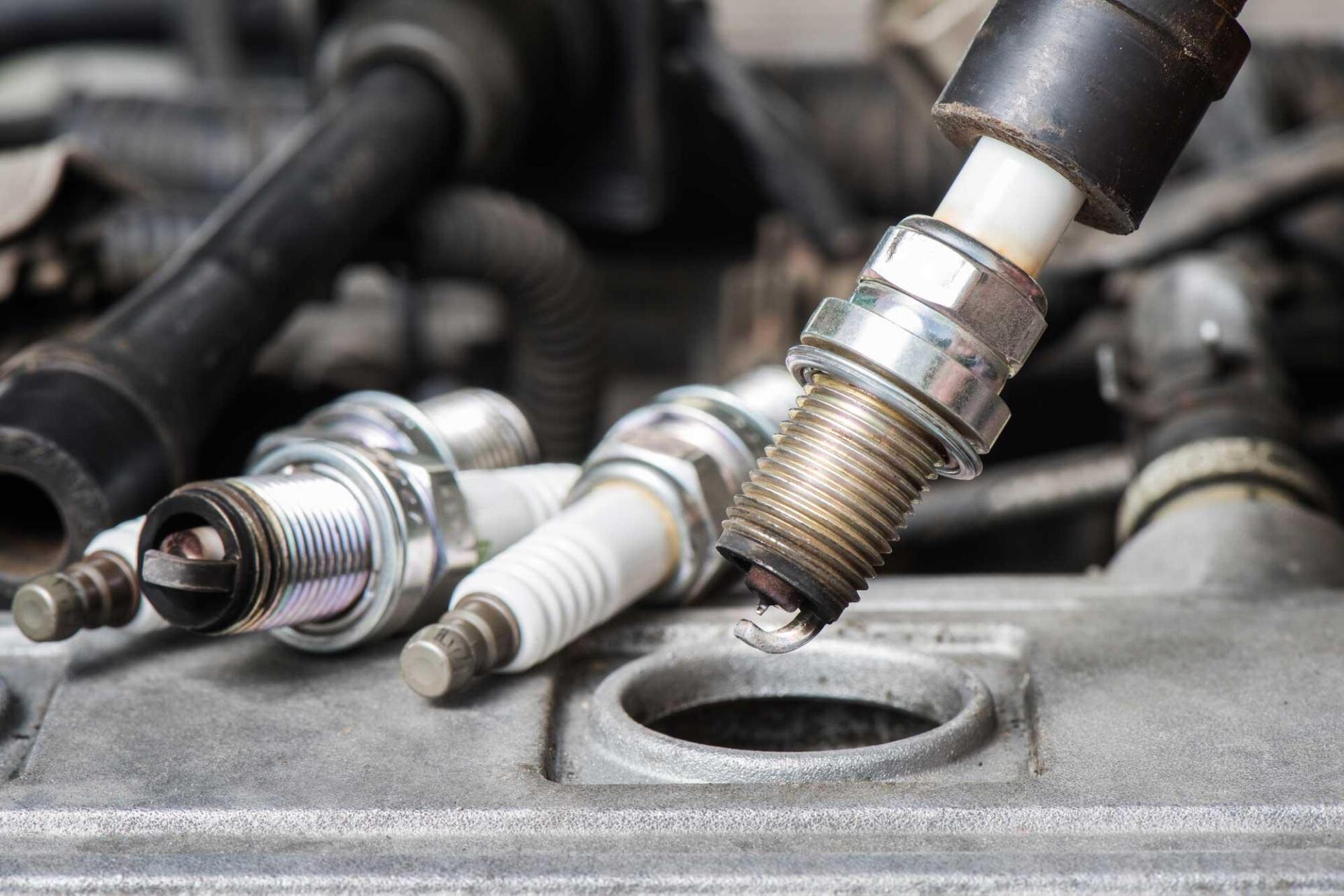 A group of spark plugs are sitting on top of a car engine.