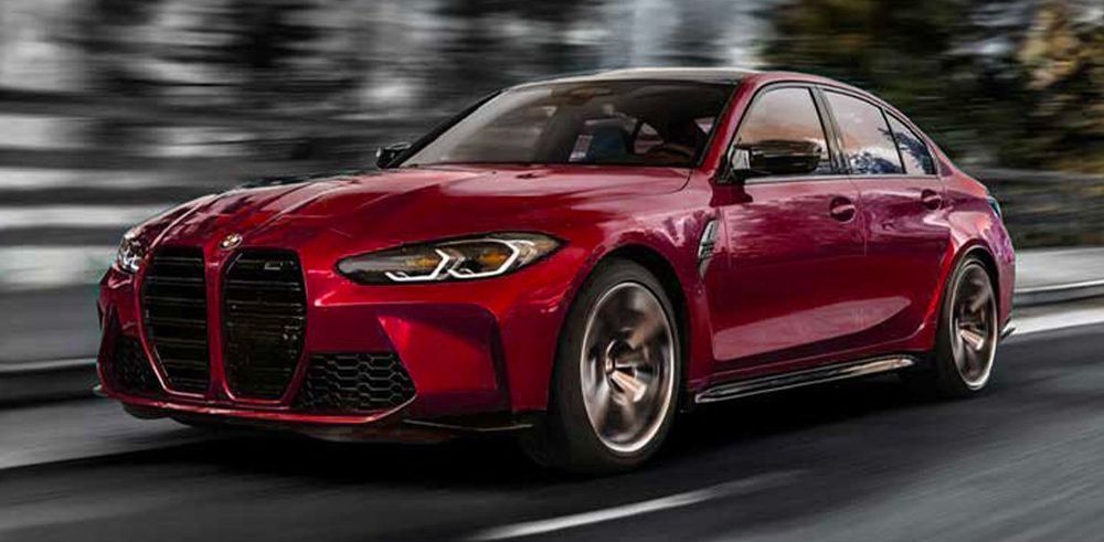 A red bmw m3 is driving down a road.