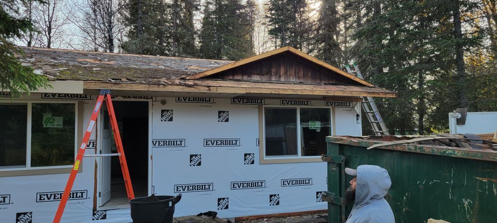 A man is standing in front of a house that is being remodeled.