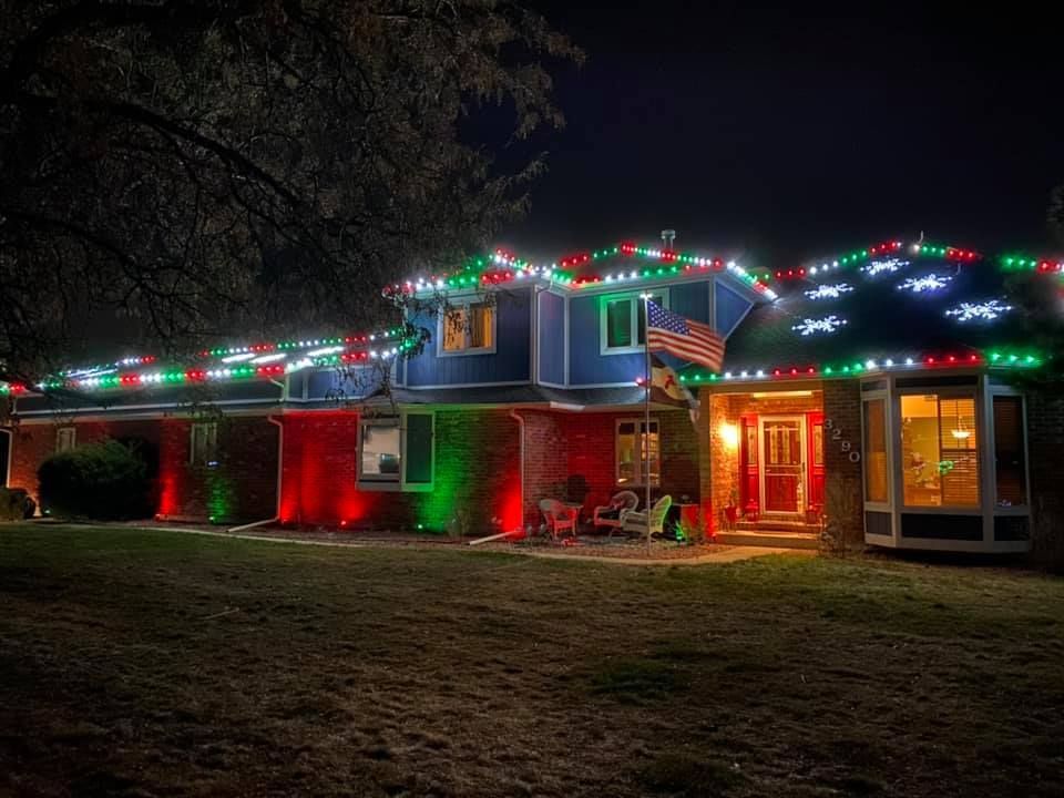 A house is decorated with christmas lights at night.