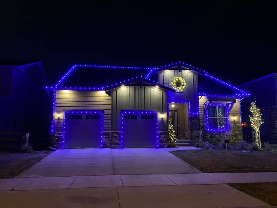 A house is decorated with blue christmas lights at night.