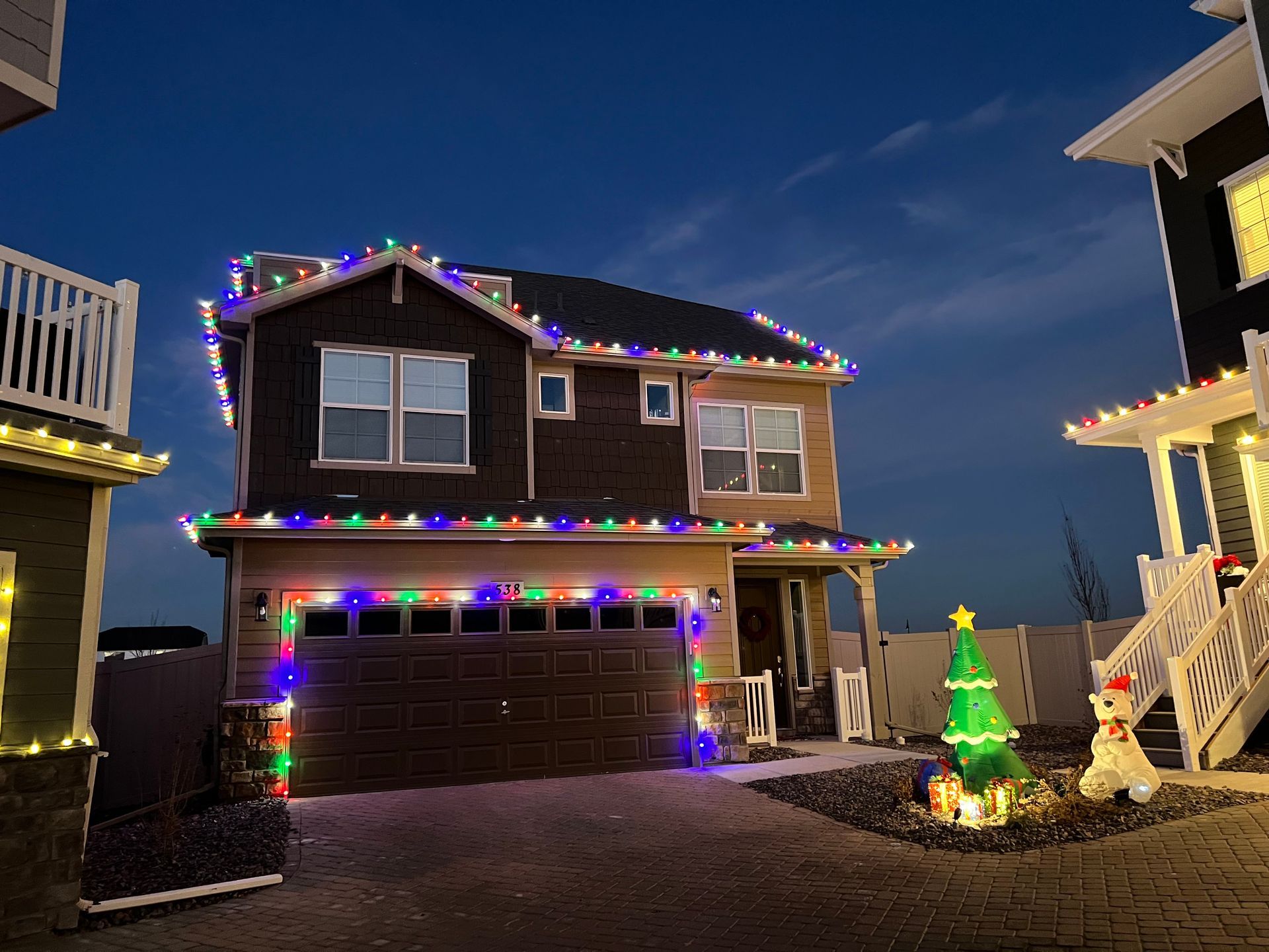 A house is decorated with christmas lights and a christmas tree.