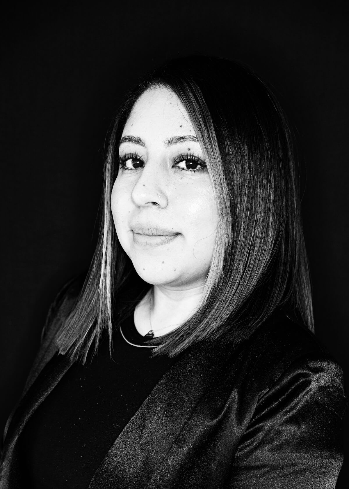 A black and white photo of a woman in a black jacket.